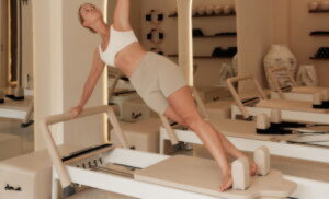 Woman doing pilates on a reformer machine.