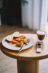 A plate of food on a table with a remote control