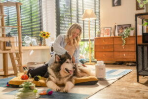 A woman sitting on the floor with two dogs